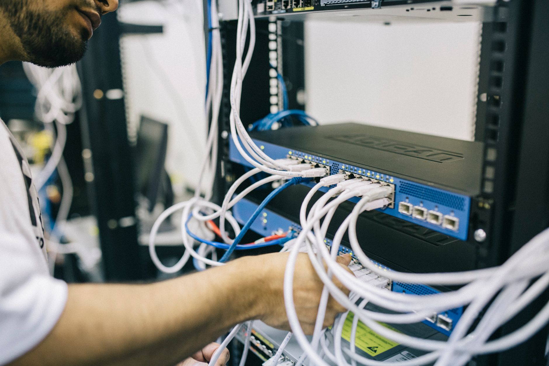 Technician configuring a wired network cabinet.